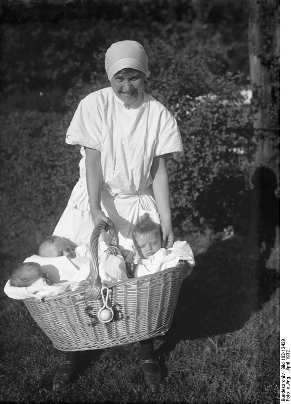 Nurse with babies. Photo from Bundesarchiv, Bild 102-13429 / CC-BY-SA.